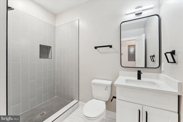 bathroom featuring vanity, toilet, and tiled shower