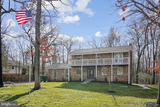 view of front property with a front yard and a balcony