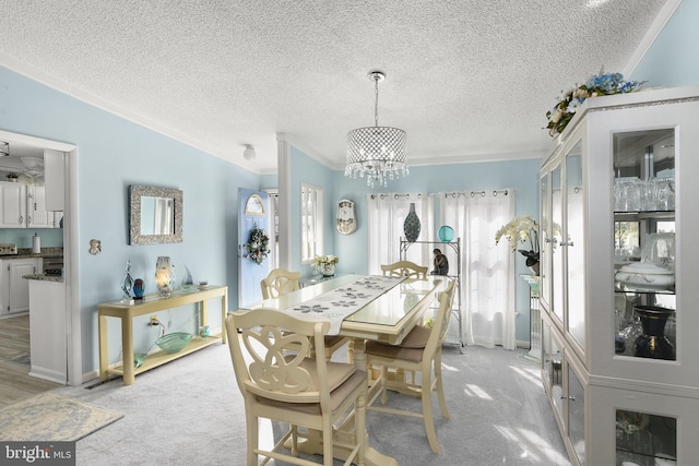 dining room with a textured ceiling, a notable chandelier, and light carpet