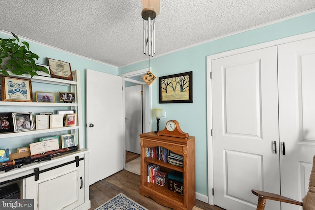 misc room featuring dark hardwood / wood-style floors, crown molding, and a textured ceiling