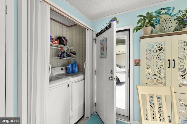 clothes washing area with a textured ceiling and washer and clothes dryer