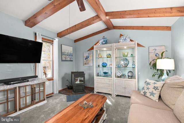 carpeted living room with lofted ceiling with beams, a wood stove, and ceiling fan