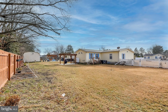 rear view of property featuring a lawn and a storage shed