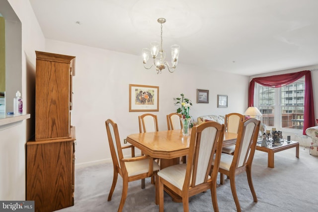 dining area with carpet floors and a notable chandelier