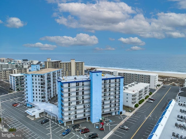 birds eye view of property with a water view and a beach view