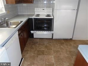 kitchen with decorative backsplash, sink, and white appliances