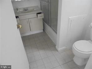 full bathroom with tile patterned floors, vanity, toilet, and bath / shower combo with glass door