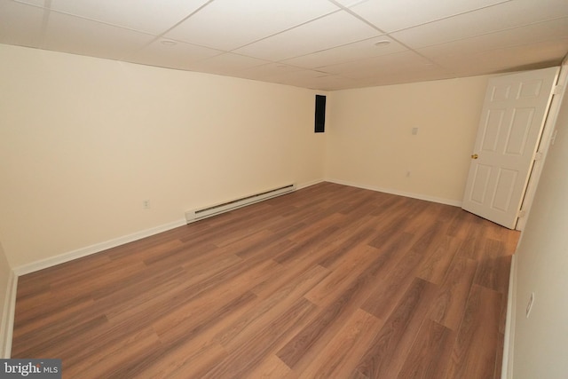 basement with wood-type flooring, a paneled ceiling, and a baseboard heating unit