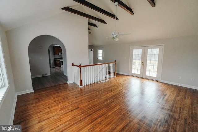 empty room featuring french doors, vaulted ceiling with beams, ceiling fan, and wood-type flooring