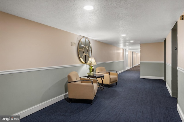 living area with a textured ceiling and dark colored carpet