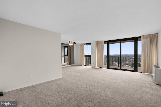 unfurnished living room featuring light carpet, floor to ceiling windows, a healthy amount of sunlight, and ceiling fan