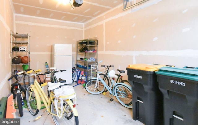 garage with a garage door opener and white refrigerator