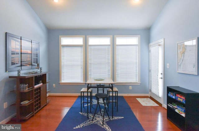 dining space with dark wood-type flooring, lofted ceiling, and plenty of natural light