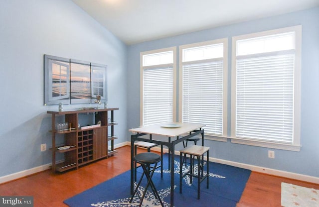 dining area featuring dark wood-type flooring and lofted ceiling