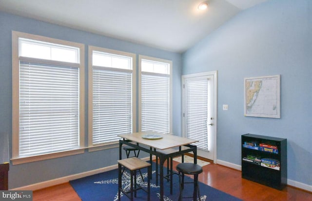 dining area with vaulted ceiling and dark hardwood / wood-style flooring