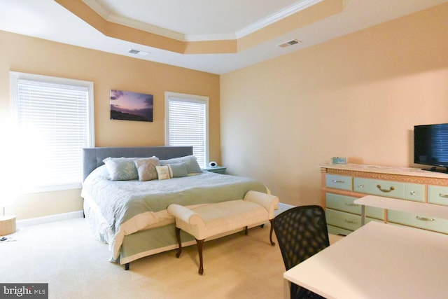 carpeted bedroom featuring crown molding and a tray ceiling