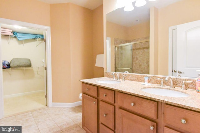 bathroom featuring tile patterned floors, an enclosed shower, vanity, and toilet