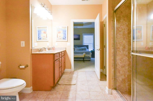 bathroom featuring toilet, tile patterned flooring, walk in shower, and vanity