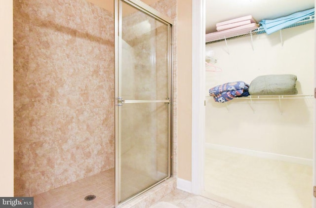 bathroom with tile patterned floors and a shower with door