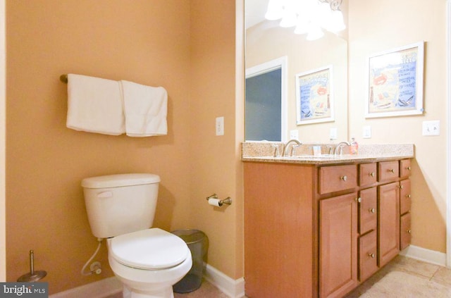 bathroom featuring toilet, an inviting chandelier, tile patterned floors, and vanity