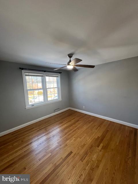 empty room featuring wood-type flooring and ceiling fan