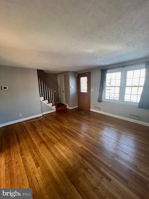 entryway with a textured ceiling and dark hardwood / wood-style floors