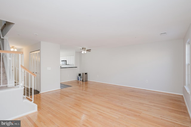 unfurnished living room featuring ceiling fan and light hardwood / wood-style flooring