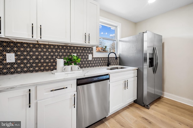 kitchen featuring light stone countertops, white cabinetry, appliances with stainless steel finishes, and sink