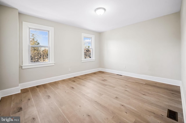 unfurnished room featuring a healthy amount of sunlight and light wood-type flooring