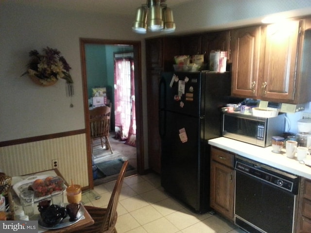 kitchen with light tile patterned floors and black appliances