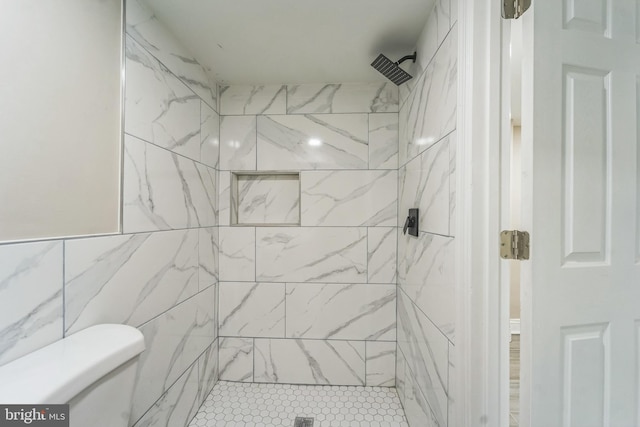 bathroom featuring a tile shower, tile walls, and toilet