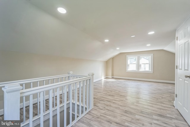 bonus room featuring vaulted ceiling and light wood-type flooring