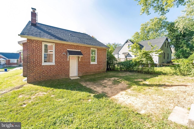 rear view of property featuring a lawn