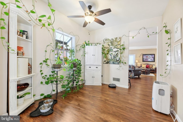 misc room with ceiling fan and dark wood-type flooring