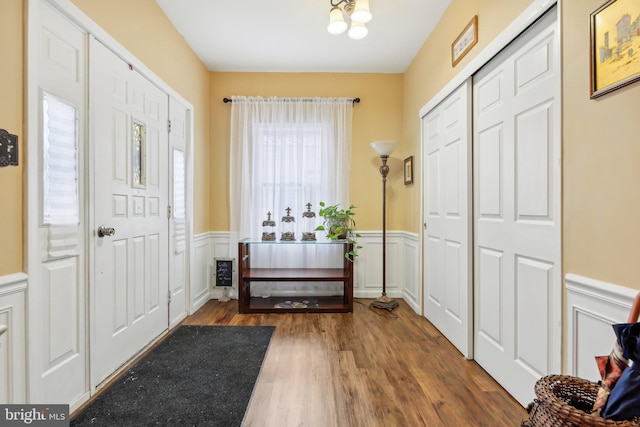 entryway featuring dark wood-type flooring and an inviting chandelier