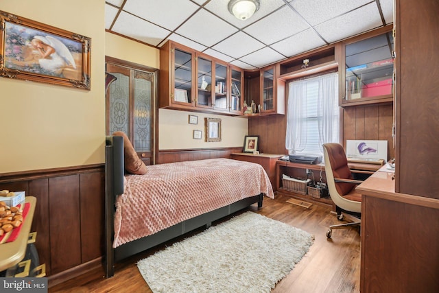 bedroom with a paneled ceiling and light hardwood / wood-style flooring