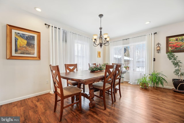 dining space featuring dark wood-type flooring and a chandelier