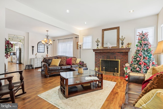 living room featuring a fireplace, dark wood-type flooring, and a notable chandelier