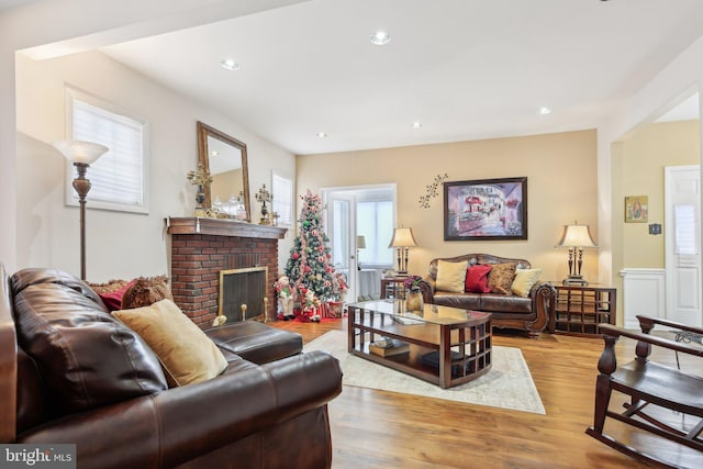 living room with light wood-type flooring and a brick fireplace