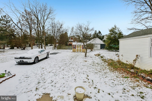 yard covered in snow featuring a storage unit