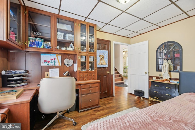 bedroom with a paneled ceiling and dark hardwood / wood-style floors