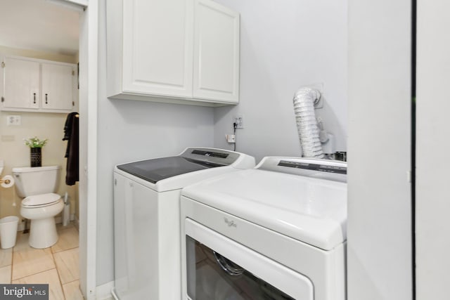 washroom with cabinets and washer and clothes dryer