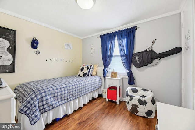 bedroom featuring dark hardwood / wood-style flooring, lofted ceiling, and crown molding