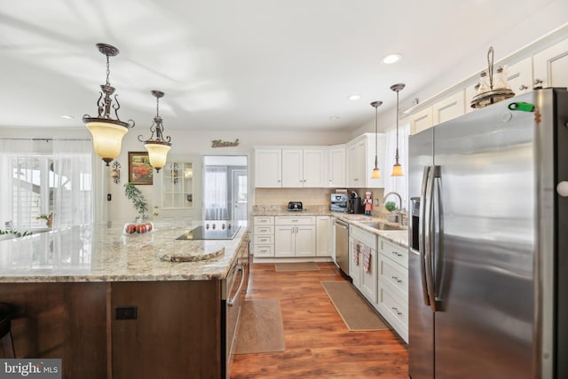 kitchen featuring dark hardwood / wood-style floors, a kitchen island, stainless steel appliances, and hanging light fixtures