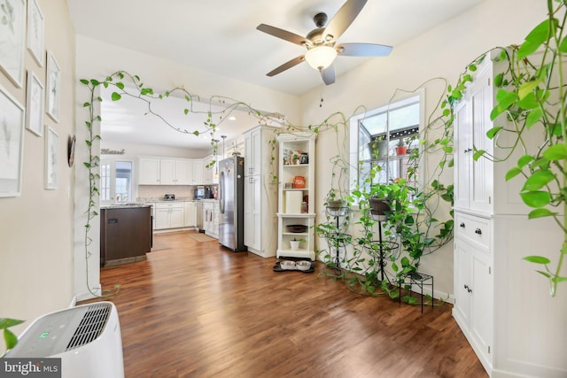 kitchen featuring stainless steel fridge, white cabinets, dark hardwood / wood-style floors, and ceiling fan