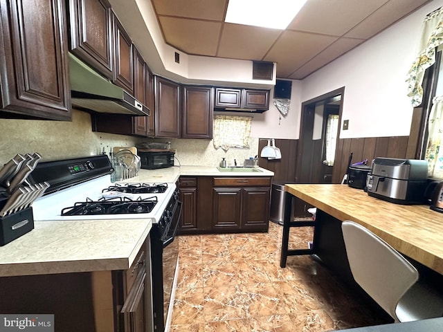 kitchen featuring a drop ceiling, exhaust hood, sink, dark brown cabinets, and white range with gas cooktop