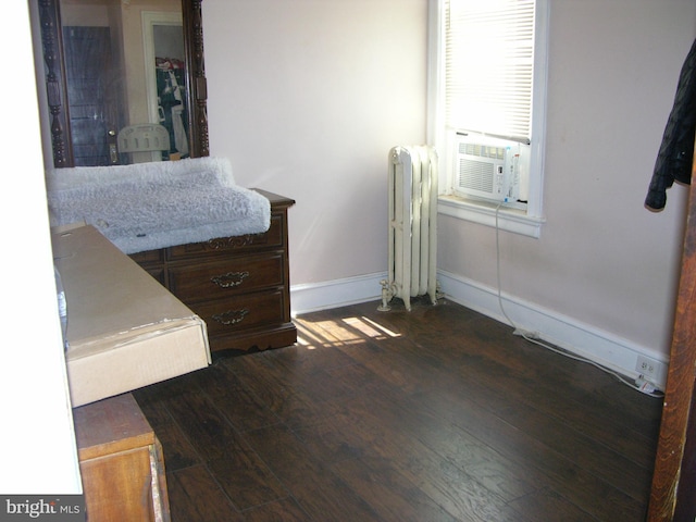 bedroom with radiator, cooling unit, and dark wood-type flooring