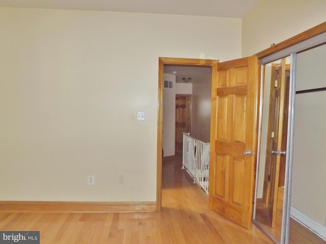 hallway with hardwood / wood-style flooring