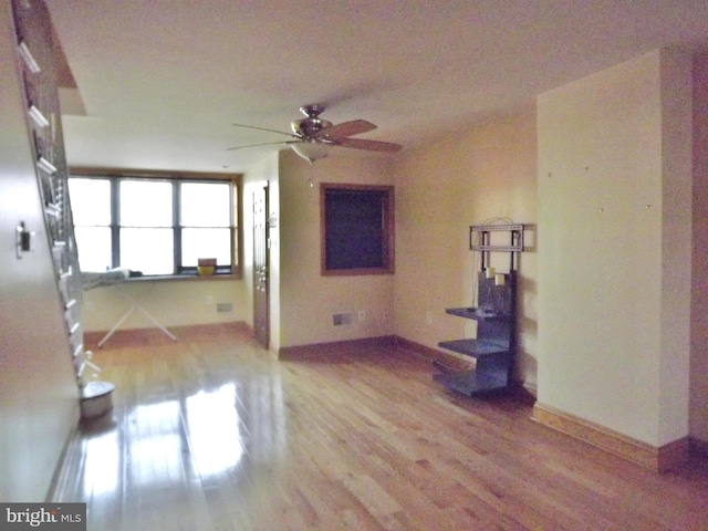 unfurnished living room featuring ceiling fan and wood-type flooring