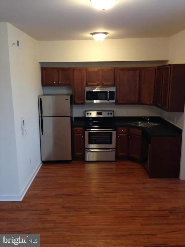 kitchen featuring dark wood-type flooring, sink, and stainless steel appliances